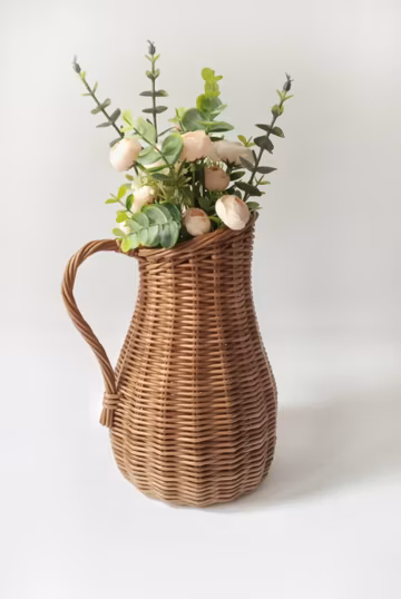 Wicker vase for flowers. Basket for artificial flowers or dried flowers. Decorative jug for home decoration. Photo props for home.